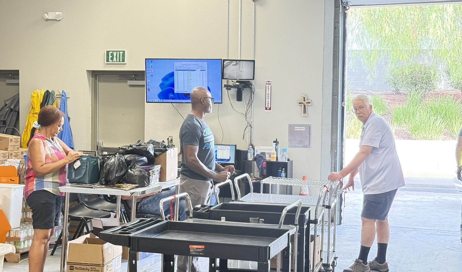 Volunteers packing food on a real distribution morning, with carts at the garage door