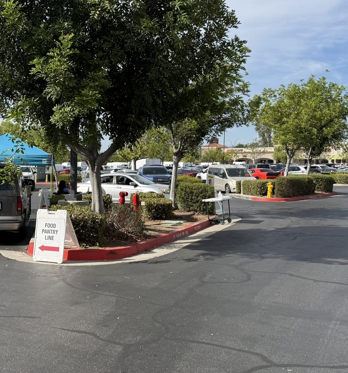 Parking-lot sign reading Food Pantry Line with a check-in tent ahead